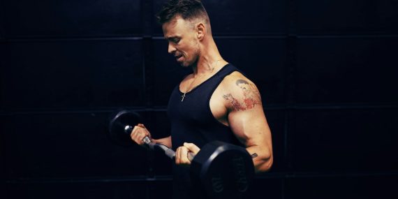 woman in black tank top holding dumbbell